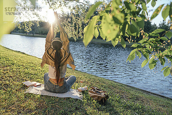 Frau mit gefalteten Händen am See im Park