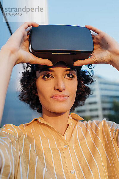 Nachdenkliche Frau mit Virtual-Reality-Headset