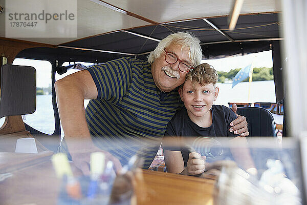 Glücklicher Großvater umarmt Enkel im Boot
