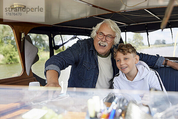 Aufgeregter älterer Mann mit Enkel im Boot
