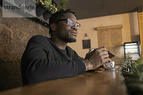 Nachdenklicher Mann mit Brille im Café