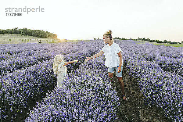 Mutter und Tochter stehen inmitten von Lavendelpflanzen