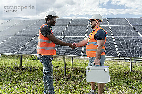 Ingenieur schüttelt Kollegen an Solarstation die Hand