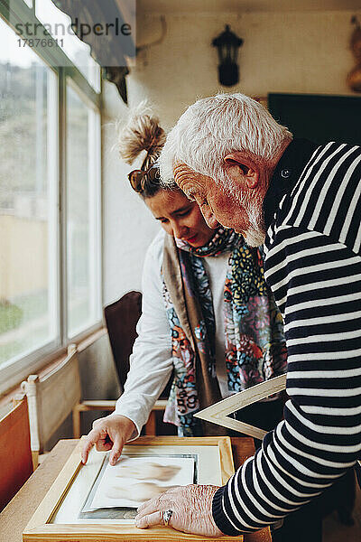 Ältere Männer und Frauen untersuchen Gemälde zu Hause