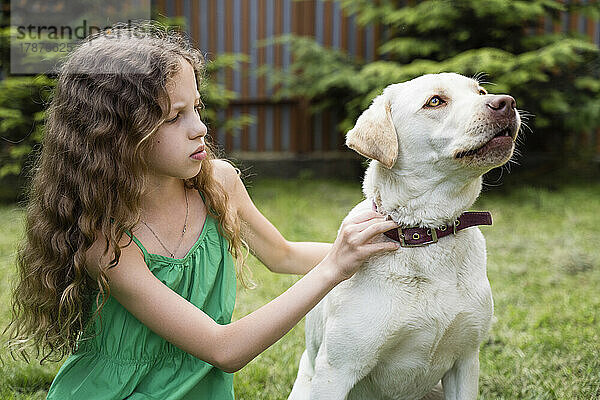 Mädchen justiert Hundeleine im Hinterhof