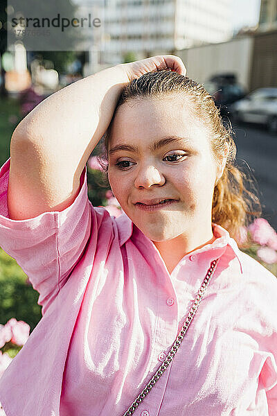 Lächelnder Teenager im rosa Hemd