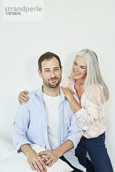 Happy man with mother spending time together at home