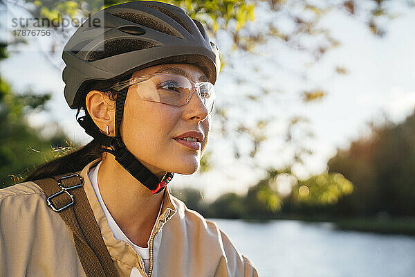 Frau mit Fahrradhelm und Schutzbrille im Park