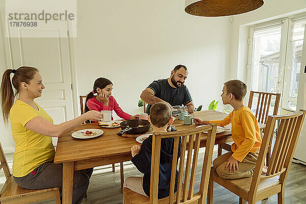 Glückliche Familie  die zu Hause frühstückt