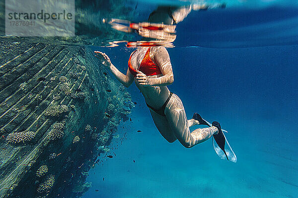 Woman swimming underwater in sea