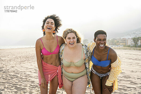 Gemischtrassige Freunde lachen im Urlaub am Strand