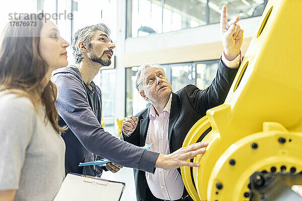 Senior customer getting advise on industrial robot from expert staff