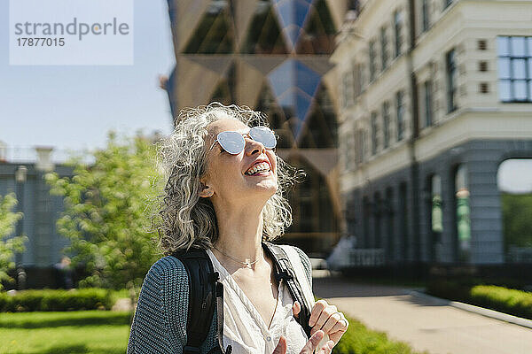 Glückliche Frau mit Sonnenbrille an einem sonnigen Tag