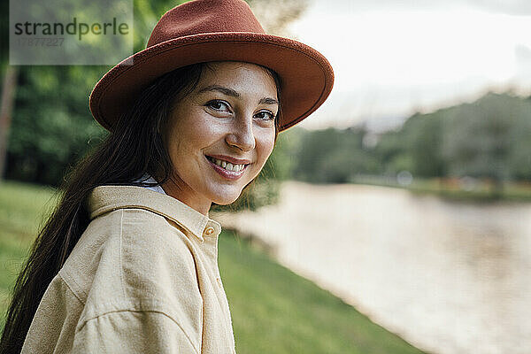 Glückliche Frau mit Hut im Park