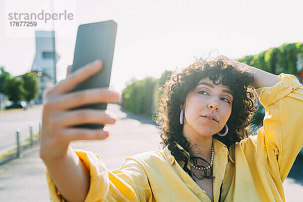 Frau posiert und macht ein Selfie mit dem Smartphone