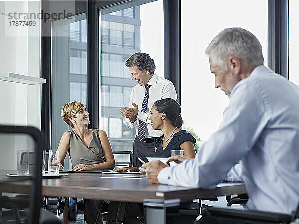 Glückliche Geschäftskollegen  die sich im Sitzungssaal treffen