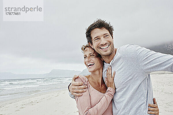 Zärtliches Paar umarmt sich am Strand
