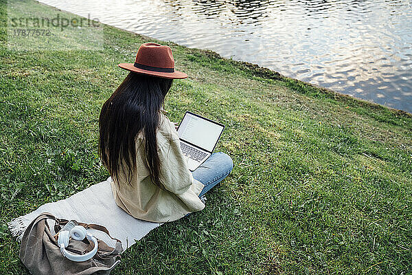 Freiberufler arbeitet am Laptop vor dem See im Park