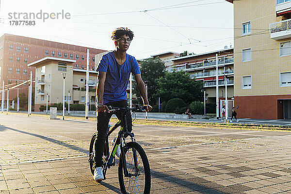 Junger Mann fährt Fahrrad in der Stadt