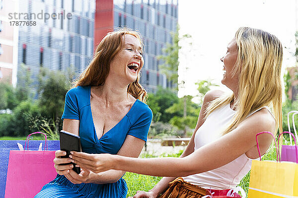 Freunde lachen mit Smartphone in der Hand