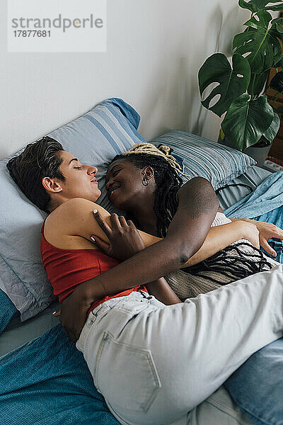 Lesbisches Paar schläft und umarmt sich zu Hause im Bett