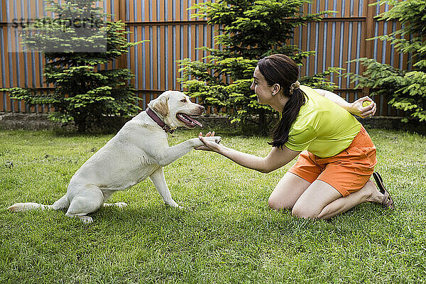 Glückliche Frau mit Hund im Hinterhof