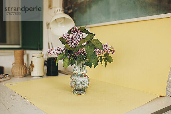 Flower vase on yellow paper at home