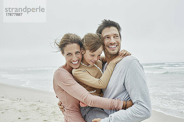 Sorglose Familie mit Tochter am Strand