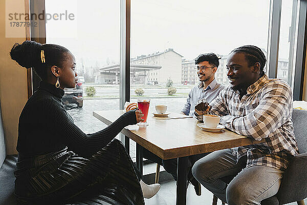 Gemischtrassige Freunde verbringen Zeit miteinander im Café