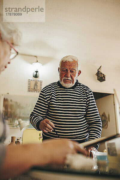 Älterer Mann im Gespräch mit Künstler zu Hause