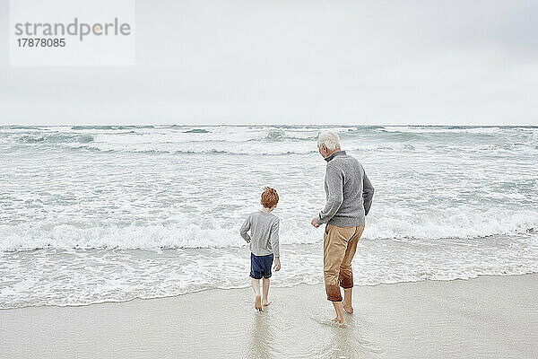 Großvater spielt mit Enkel am Meer