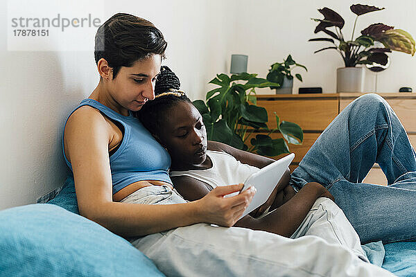 Lesbisches Paar beobachtet Saufgelage über Tablet-PC im heimischen Bett