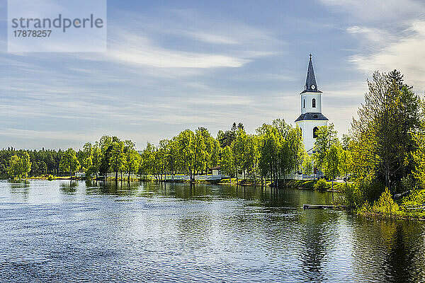 Schweden  Kreis Vasterbotten  Sorsele  See im Sommer mit dem Glockenturm der Kirche im Hintergrund