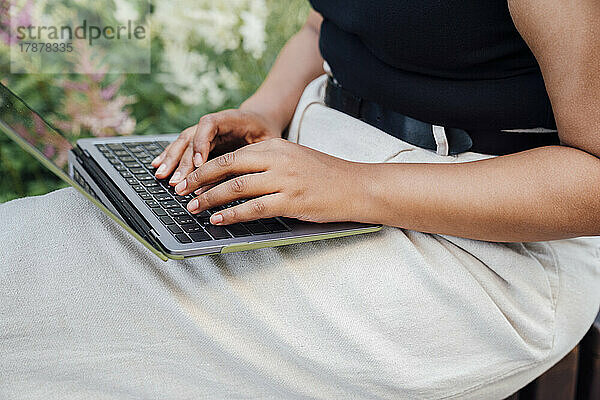Hands of businesswoman typing on laptop
