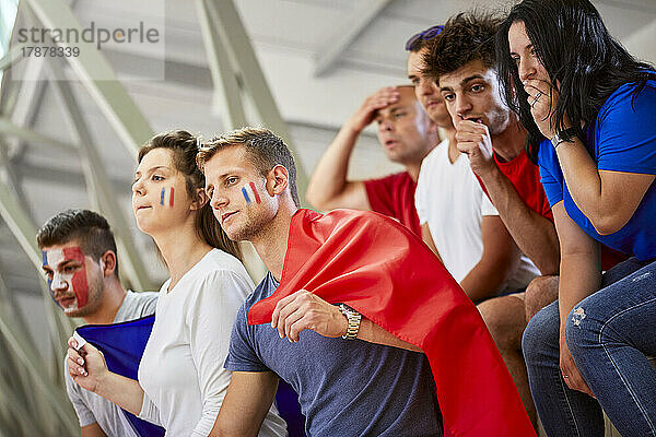 Neugierige Fans mit französischer Flagge schauen sich Sportereignisse im Stadion an
