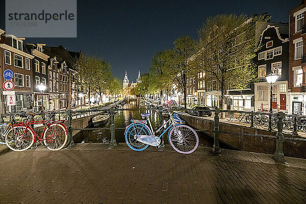 Niederlande  Nordholland  Amsterdam  Fahrräder stehen nachts entlang der Kanalbrücke