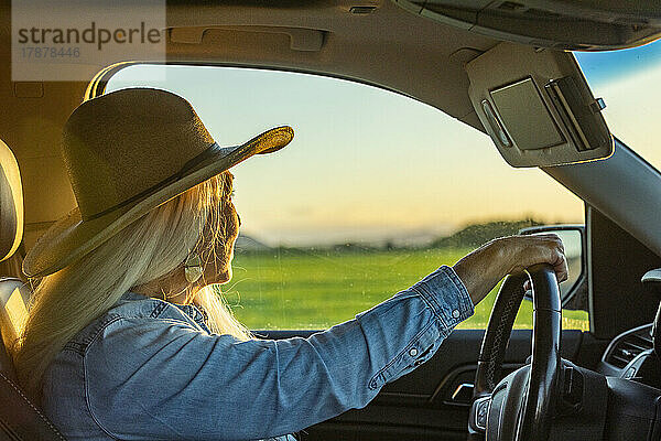 Blonde Frau im Auto mit Cowboyhut