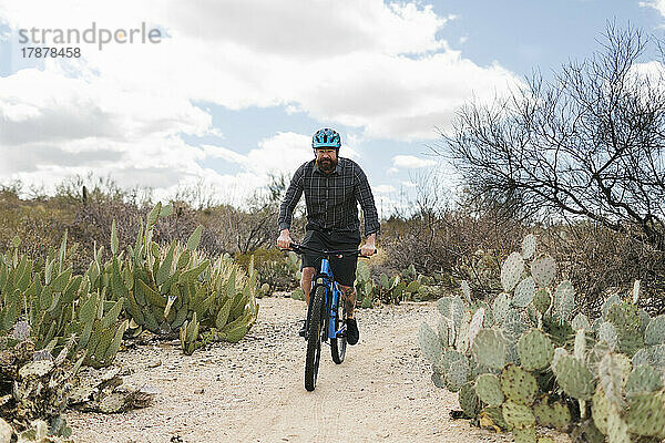 Mann fährt Fahrrad in der Wüste