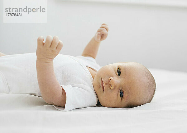 Porträt eines neugeborenen Jungen (0-1 Monat)  der auf dem Bett liegt
