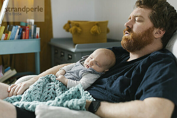 Vater schläft mit neugeborenem Sohn (0-1 Monat)