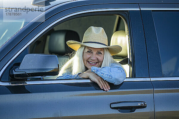Blonde Frau im Auto mit Cowboyhut
