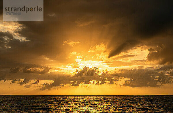 Orangefarbene Wolken über dem Meer bei Sonnenaufgang