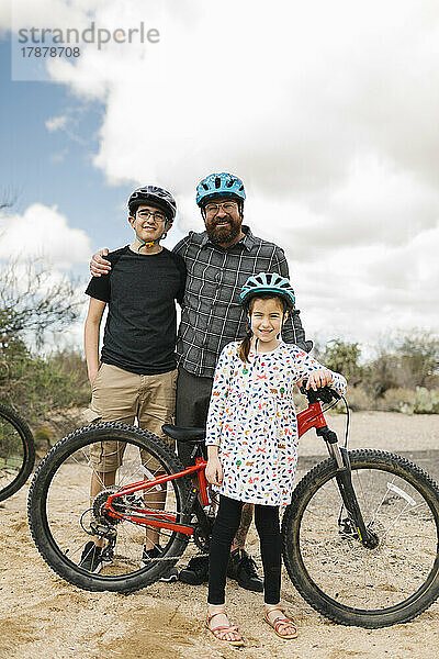 Porträt eines Vaters mit Kindern (8-9  14-15) mit Fahrrädern