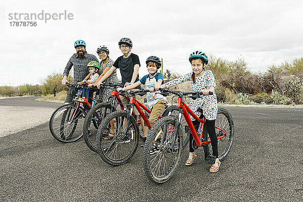 Familie mit Kindern (2-3  8-9  14-15) beim gemeinsamen Radfahren