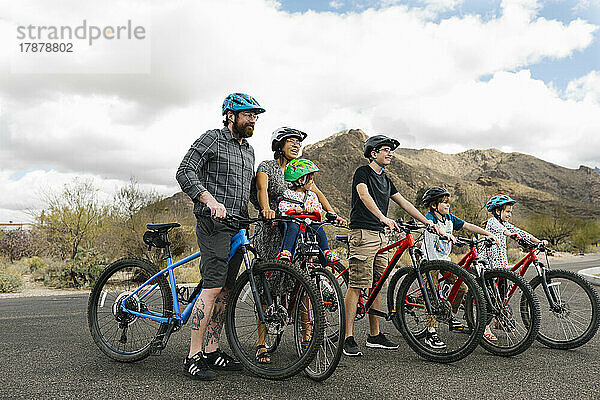 Familie mit Kindern (2-3  8-9  14-15) beim gemeinsamen Radfahren