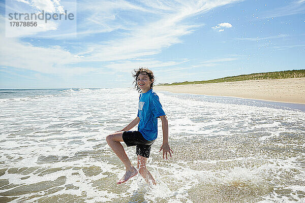 Lächelnder Junge (10-11) spielt im Meer