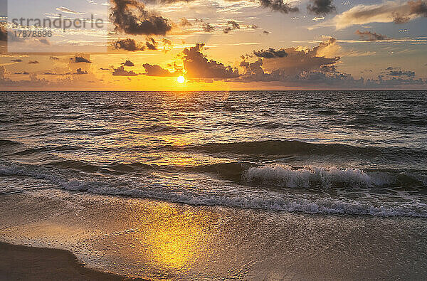 Meereswellen waschen den Strand bei Sonnenaufgang