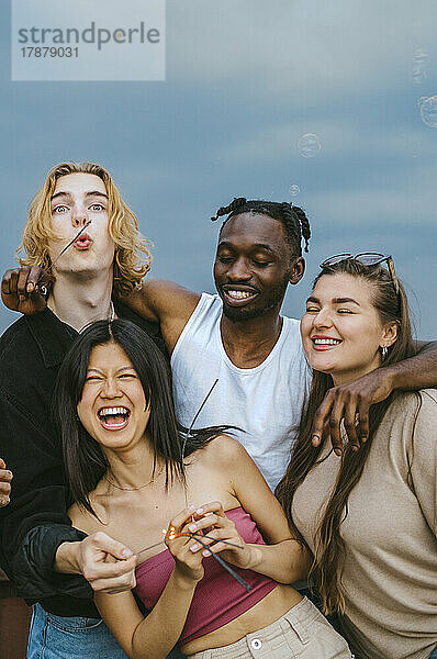 Glücklich multirassische männliche und weibliche Freunde haben Spaß zusammen gegen den Himmel