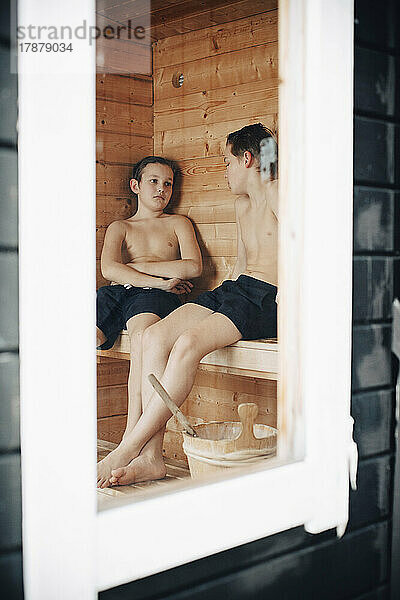 Hemdenlose Jungs reden in der Sauna durch das Fenster gesehen