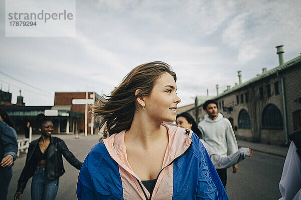 Junge Frau mit Freunden auf der Straße in der Stadt